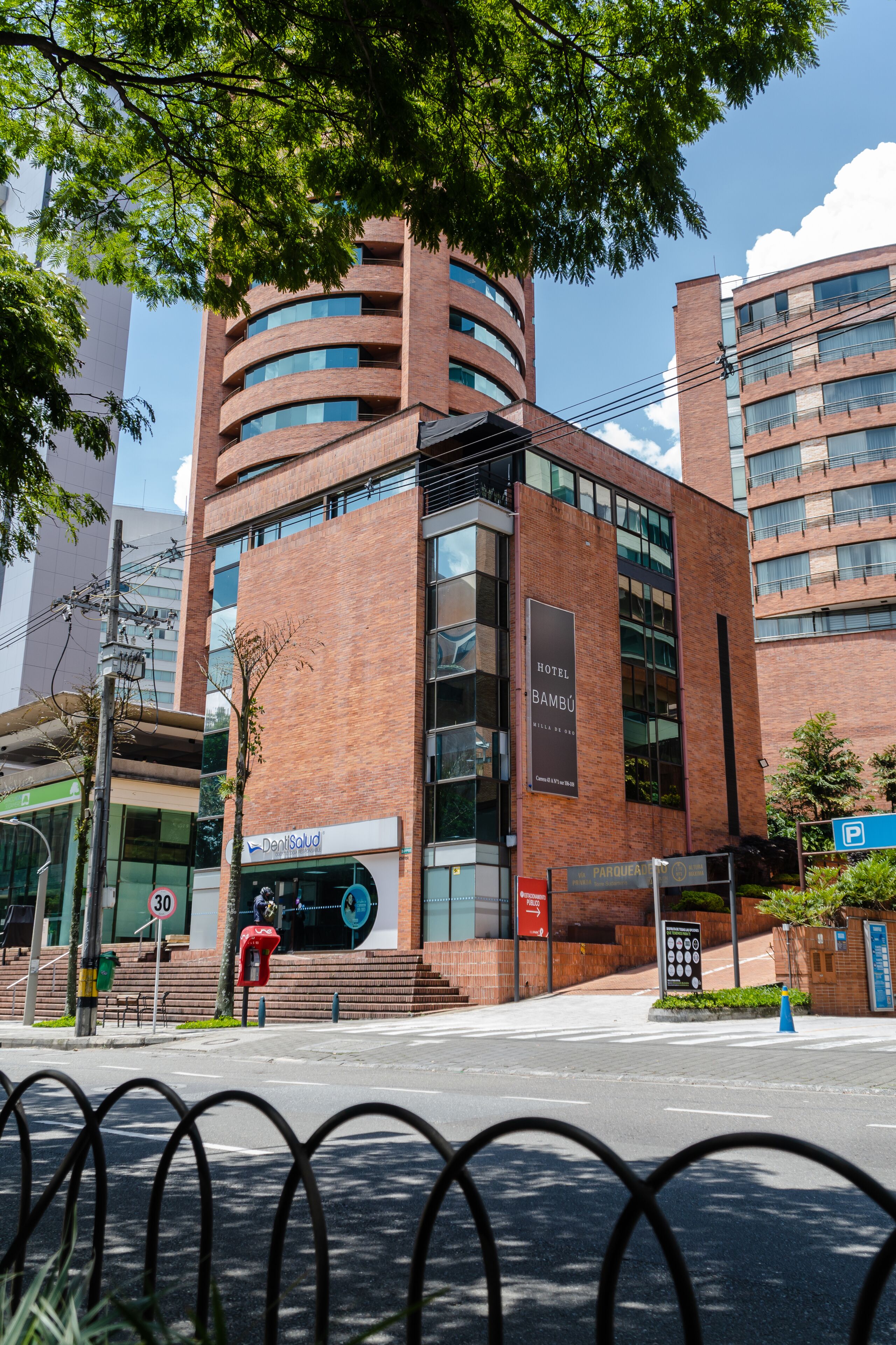 A modern hotel with a prominent "Hotel Bambú" sign, featuring a brick facade and multiple balconies.