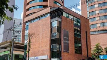 A modern hotel with a prominent "Hotel Bambú" sign, featuring a brick facade and multiple balconies.