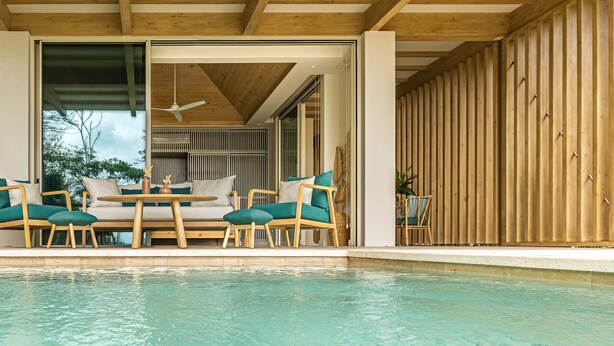 A poolside area with wooden furniture and a ceiling fan. - Casa Eos - prime location property (Santa Teresa de Cobano)