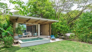 A modern outdoor pool area with a covered seating area, surrounded by lush greenery. - Casa Eos - prime location property (Santa Teresa de Cobano)