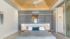 A modern bedroom with a large bed, wooden headboard, and a ceiling fan. - Casa Eos - prime location property (Santa Teresa de Cobano)