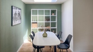 A dining area with a white table and black chairs, a white shelving unit with decorative items, and a skylight above. - Stunning home in Noordwijk with WiFi (Noordwijk)