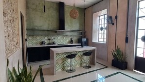 Una cocina con una isla central, un ventanal con vistas y una puerta de diseño único.
