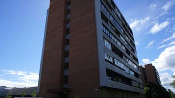 Un immeuble à plusieurs étages, doté d’une façade en briques et de nombreuses fenêtres.