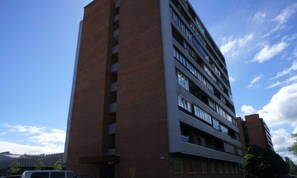 Un edificio de varios pisos con fachada de ladrillo y numerosas ventanas.