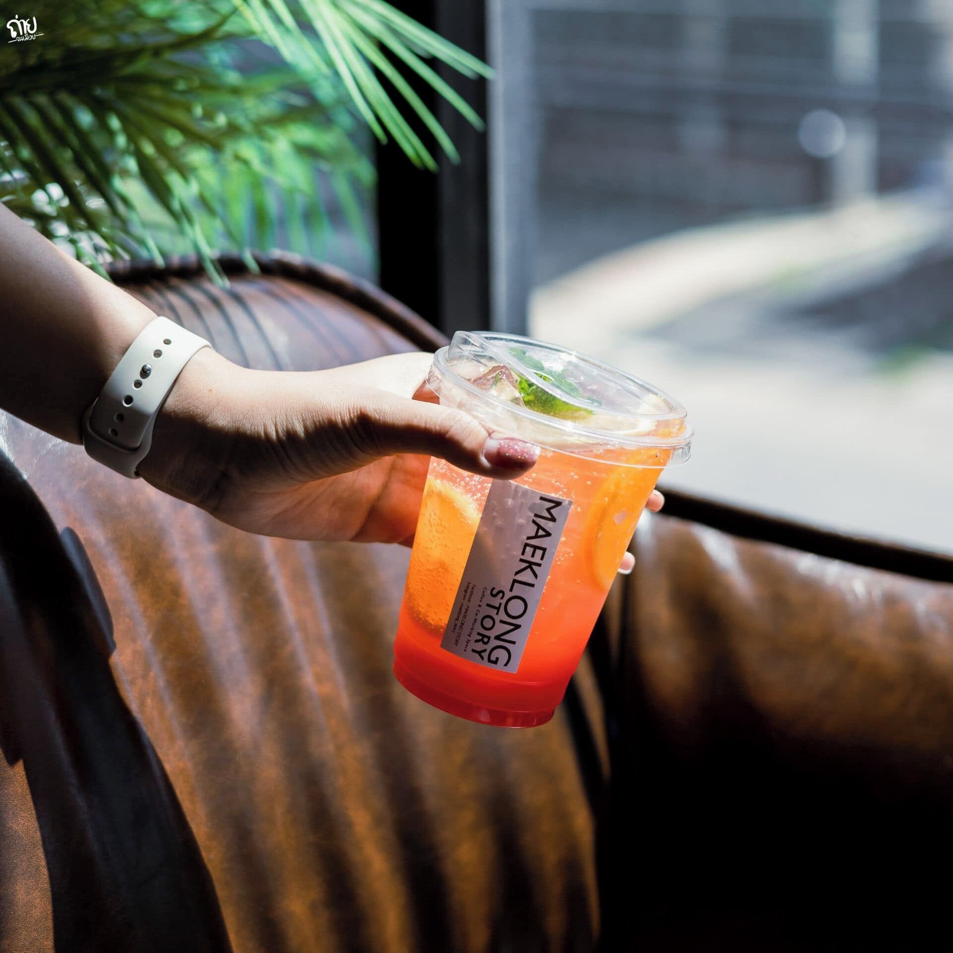 A person holding a branded drink container.
