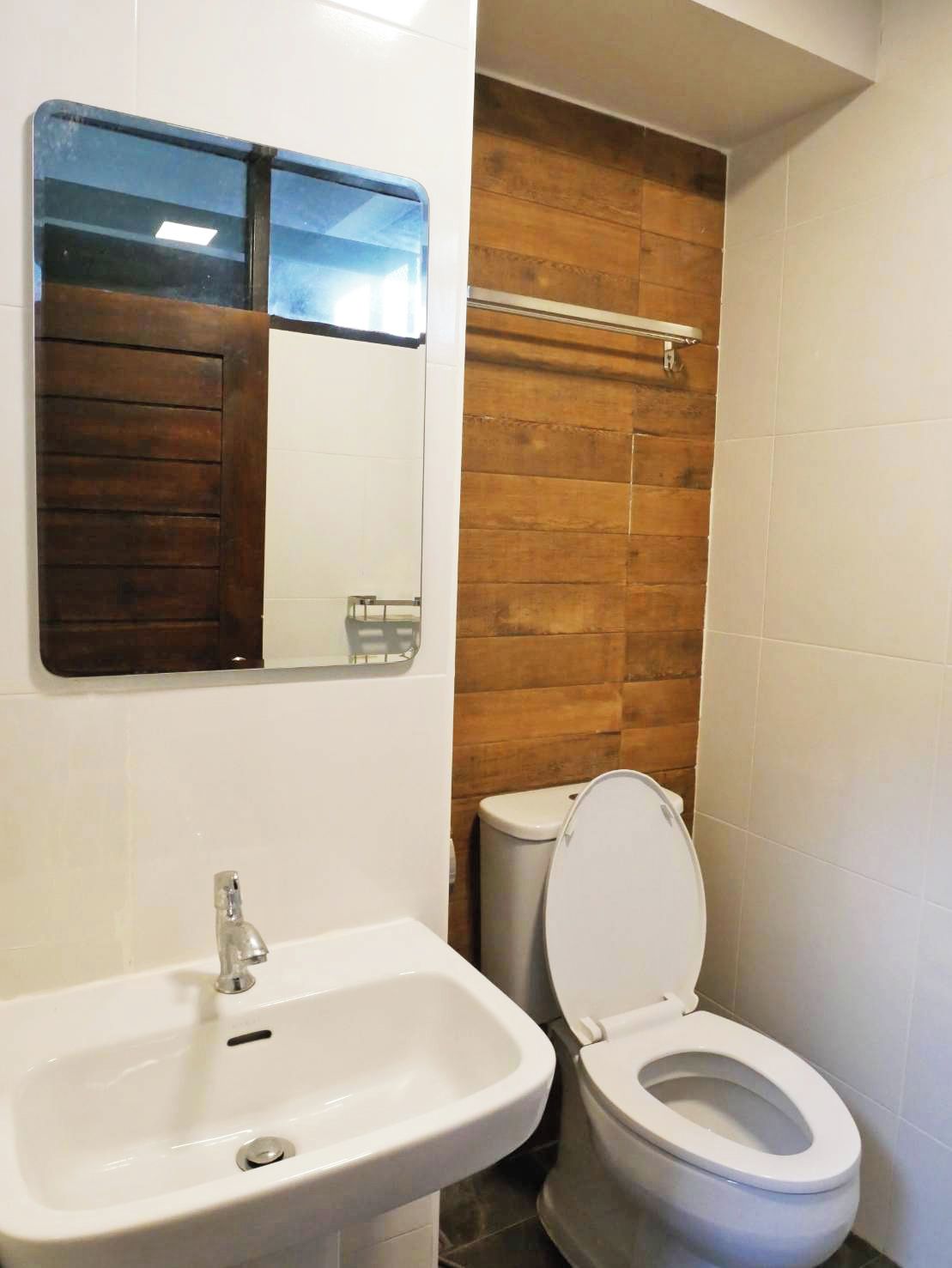 A bathroom with a white sink, a mirror, and a toilet.