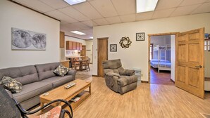 A living room with a sofa, armchair, coffee table, and a dining area with chairs and a table. - 2 Mi to Ice Caves: Pet-Friendly Eben Junction Apt (Eben Junction)