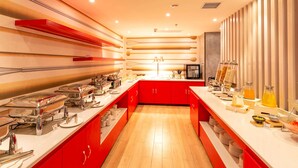 A modern kitchen with red cabinets, stainless steel appliances, and a variety of food items displayed on the counter. - Ibis Xi an Shaanxi Province People Hospital Hotel (Xi'an)