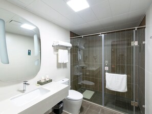 A modern bathroom with a large mirror, two sinks, a toilet, and a glass-enclosed shower area. - Ibis Xi an Shaanxi Province People Hospital Hotel (Xi'an)