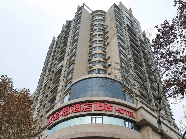A high-rise hotel with a curved facade and multiple balconies. - Ibis Xi an Shaanxi Province People Hospital Hotel (Xi'an)