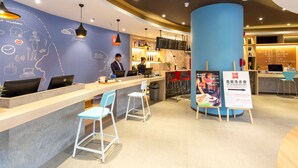 A modern hotel lobby with a reception desk, bar area, and seating. - Ibis Xi an Shaanxi Province People Hospital Hotel (Xi'an)
