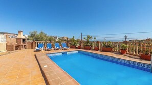A rooftop swimming pool with blue tiles, lounge chairs, and potted plants. - Villa Medina Torrox by Ruralidays (Málaga)