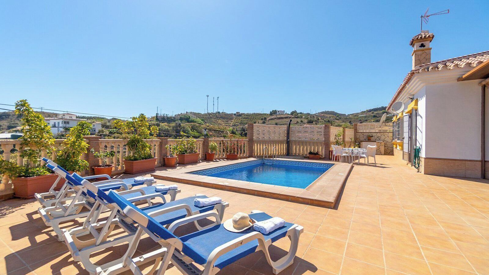 A rooftop pool area with lounge chairs and a swimming pool.