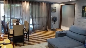 A modern living room with a sofa, a dining table with chairs, and a yellow table. - Rancho Paraíso Piscina Aquecida Mairiporã/nazaré PTA (Mairiporã)