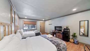 A hotel room with two beds, a TV, a microwave, and a small desk.