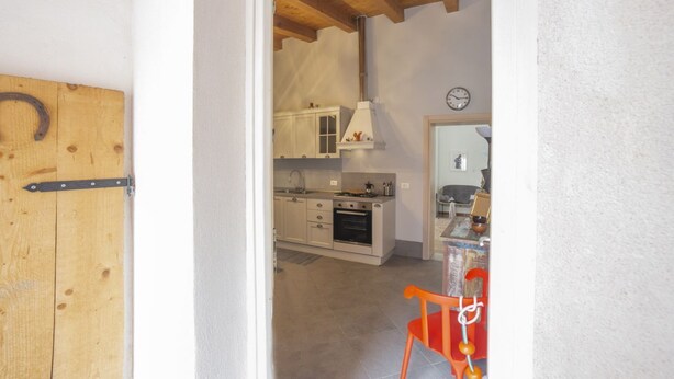 A kitchen with white cabinets, a stove, and a sink.
