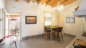 A dining area with a wooden ceiling, a chandelier, and a table with chairs.