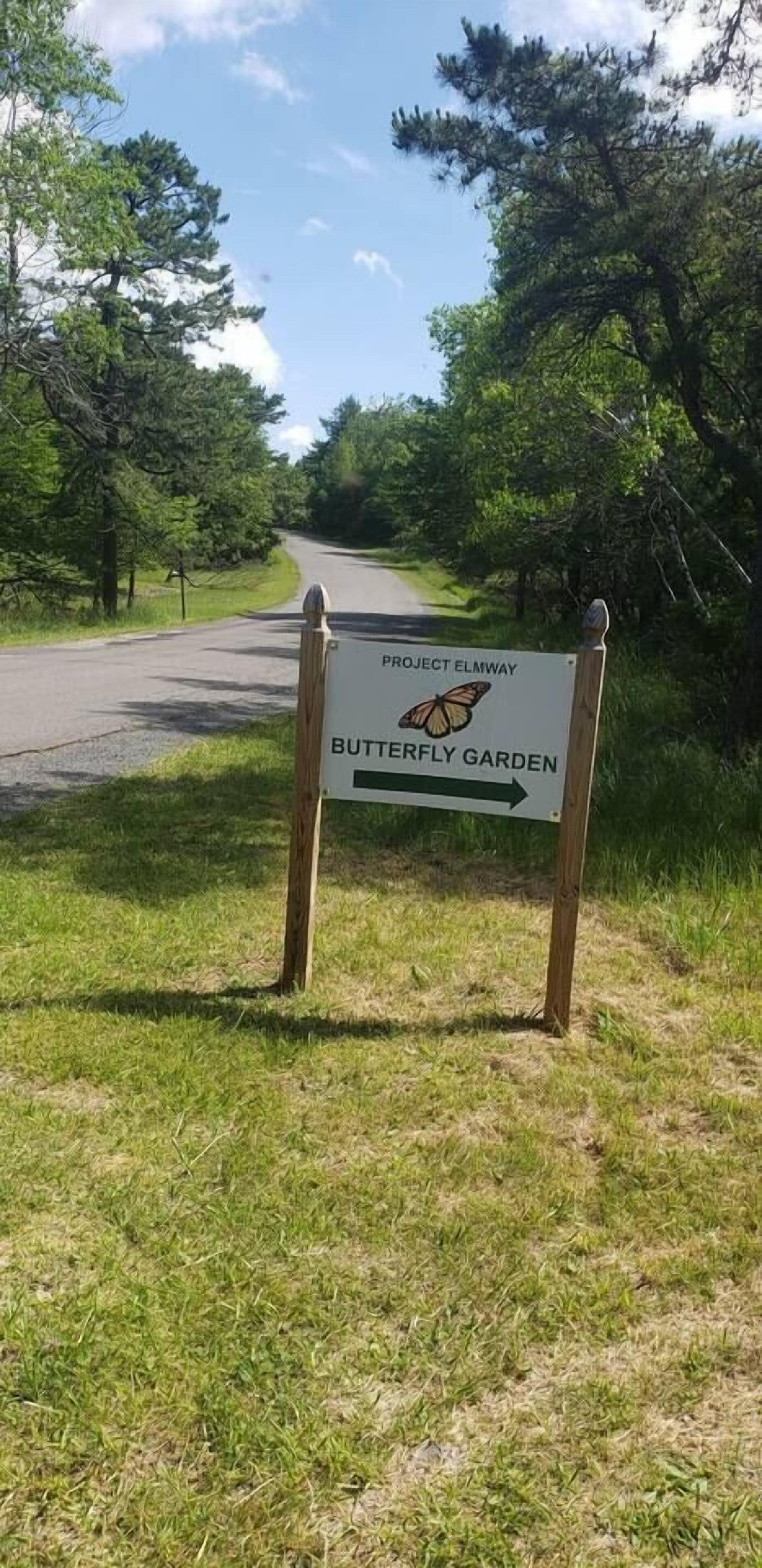 A sign for Project Elmway Butterfly Garden with a directional arrow.