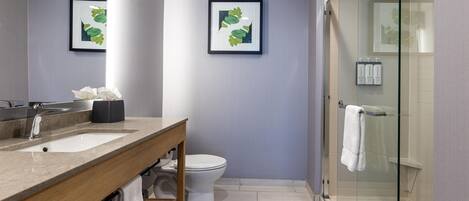 Un baño moderno con un lavamanos doble, un inodoro y una cabina de ducha de vidrio.