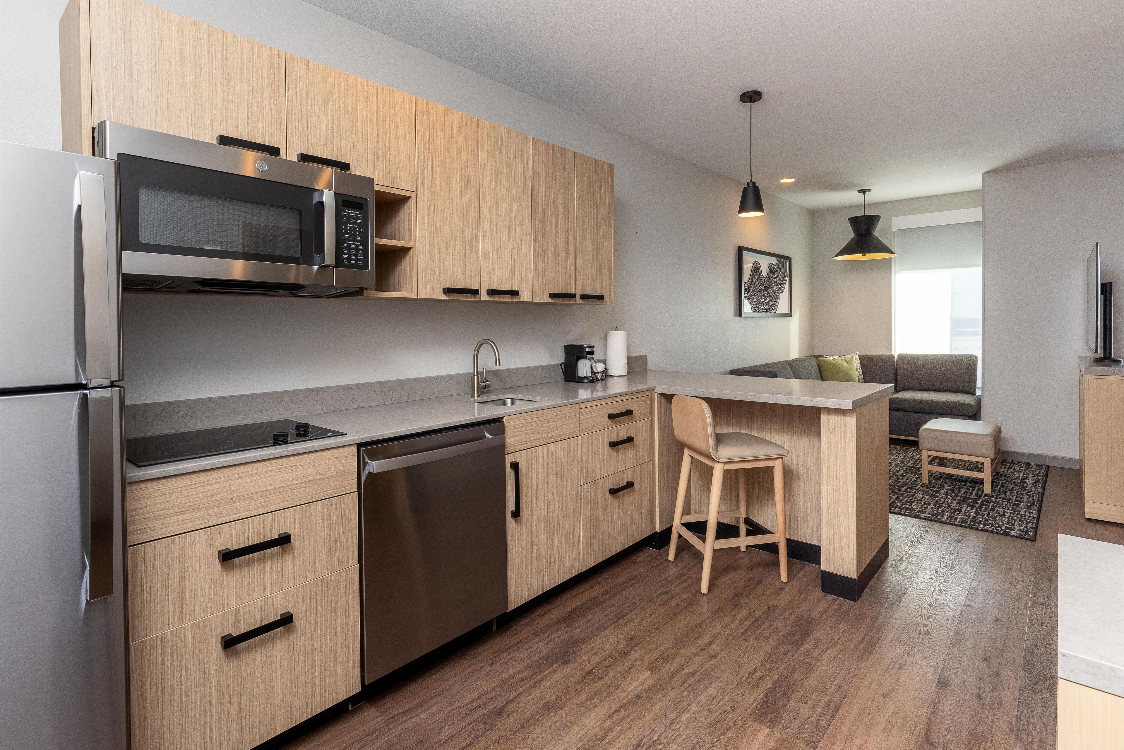Een moderne keuken met roestvrijstalen apparatuur, houten kasten en een bar.