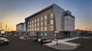 A modern hotel building with a prominent sign, multiple parking spaces, and a well-lit entrance area. - Hyatt Place Munster (Munster)