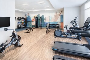A gym with treadmills, stationary bikes, a weight bench, and various exercise equipment. - Hyatt Place Munster (Munster)