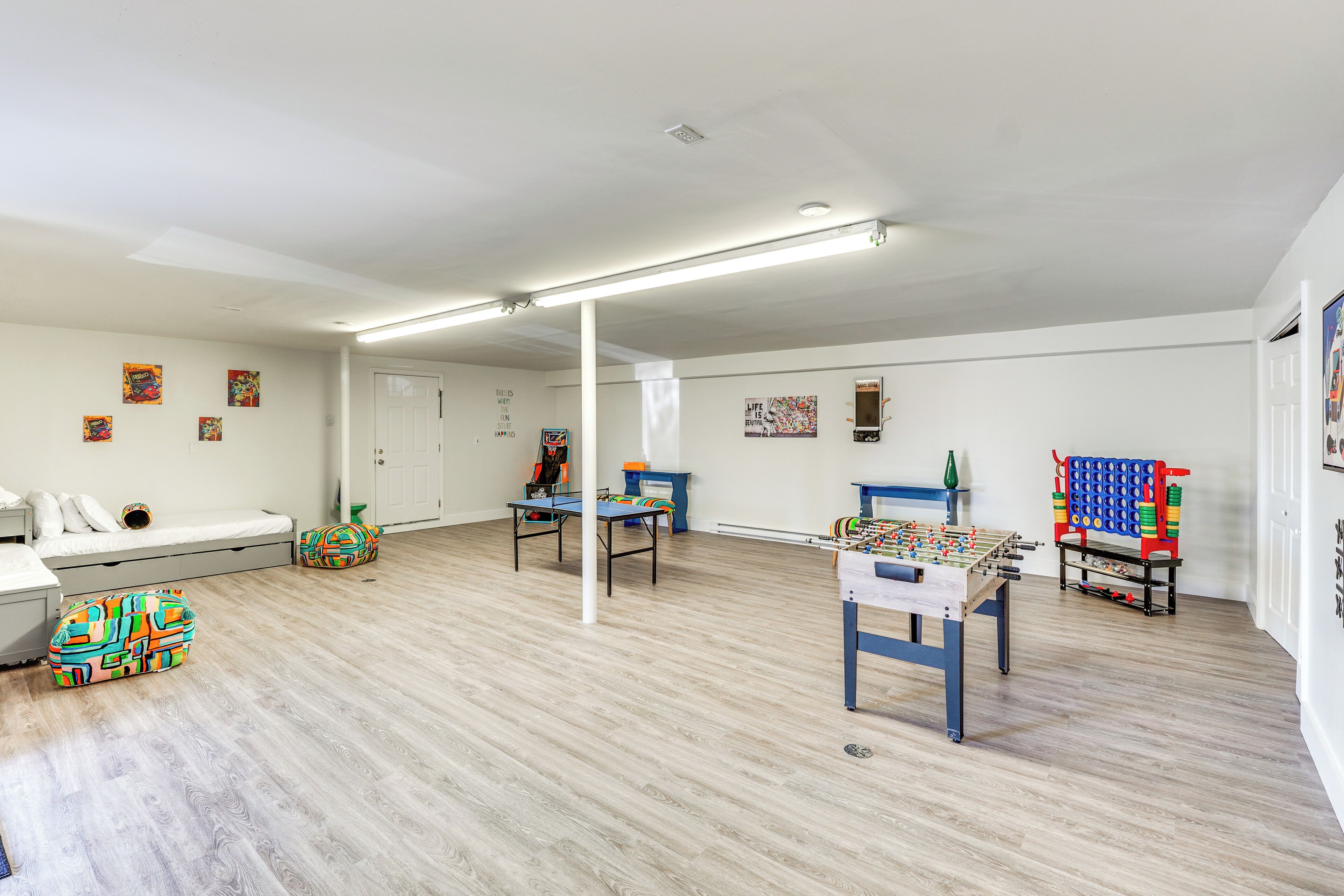 Um quarto espaçoso com mesa de pebolim, um sofá e um espaço de brincadeiras colorido.
