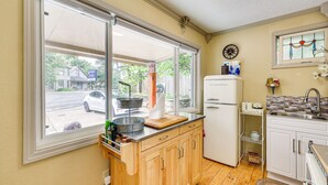 A compact kitchen with a large window, a refrigerator, and a sink. - Eureka Springs Rental - Walk to Downtown! (Eureka Springs)