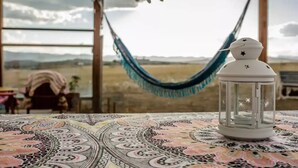 Una habitación con un mantel estampado, un farol blanco y una hamaca.