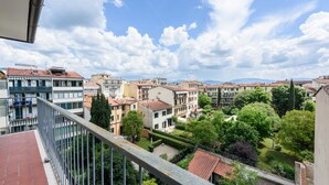 Un balcón con vistas a una zona residencial, con edificios y zonas verdes.