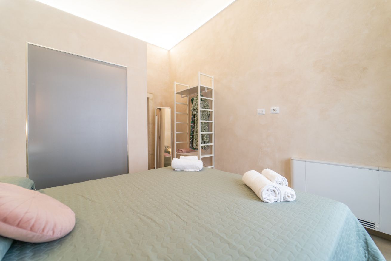 A bedroom with a bed, a closet, and a radiator.
