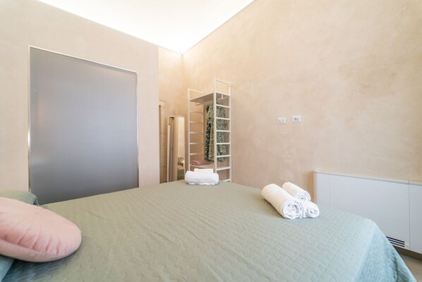 A bedroom with a bed, a closet, and a radiator.