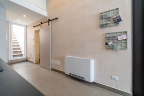 A modern interior with a sliding door, a white radiator, and wall-mounted storage units.