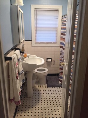 Bathroom features a pedestal sink, standard toilet, and a window with blinds.