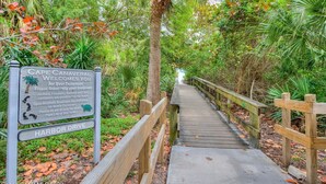 A wooden boardwalk leading to a beach area with a sign indicating rules for visitors. - Lovely Apartment Close to the Beach ! (Cape Canaveral)