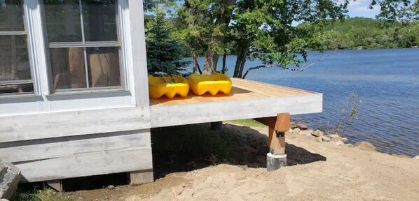 A wooden deck with yellow floating docks extending over a lake. - Beach House (Huntsville)