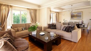 A spacious living room with two sofas, a coffee table, and a dining area with a table and chairs. - Contemporary luxury villa with eclectic design a few steps away from Varkiza bay (Vari)