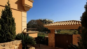 A courtyard with a stone wall, a wooden pergola, and a gate. - Contemporary luxury villa with eclectic design a few steps away from Varkiza bay (Vari)