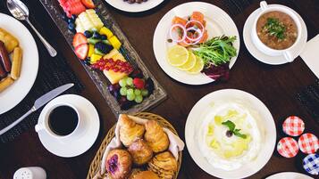 Una variedad de platos, incluyendo una fuente de frutas, sopa y pasteles, sobre una mesa.