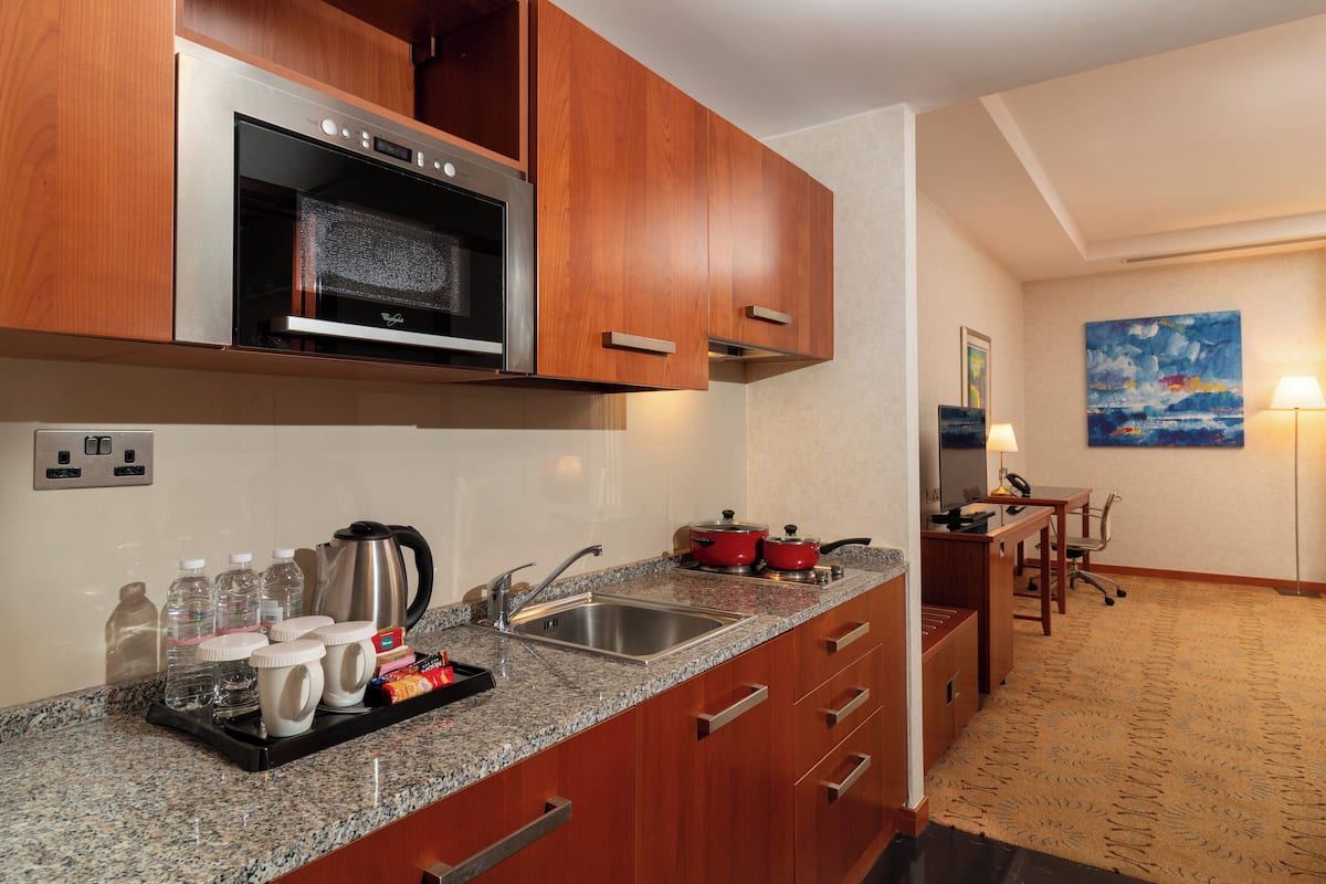 A modern kitchen with granite countertops, stainless steel appliances, and wooden cabinets.