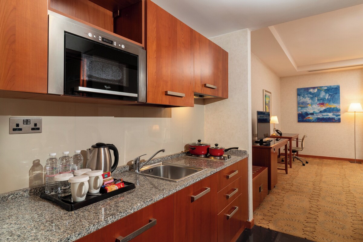 A modern kitchen with granite countertops, stainless steel appliances, and wooden cabinets.