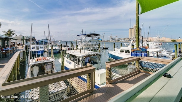 A marina with multiple boats docked, a restaurant with outdoor seating, and a clear view of the water. - Beautiful Condo Two Blocks to The Beach ! (Cape Canaveral)