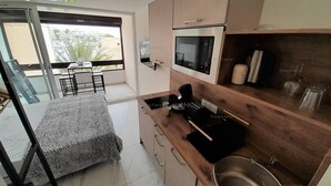A modern kitchen with a built-in microwave, a coffee machine, and a sink. - Studio Port Venus Sensation (LE CAP D'AGDE)