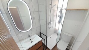 A modern bathroom with a white sink, mirror, and toilet. - Studio Port Venus Sensation (LE CAP D'AGDE)