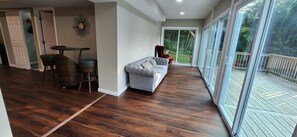 Sunroom with large couch and accent red chair - Lake House w/2 huge decks/2 sunrooms/shower panel w/6 modes/beach nearby
 (Winchester)