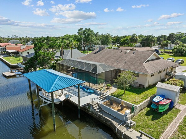 A residential property with a dock, a swimming pool, and a covered patio area. - Manatees Coming Waterfront Deep canal.Gulf access.Pool home! Pool table.Sleeps8. (Crystal River)