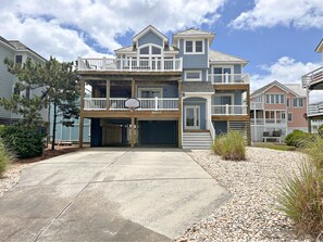 A two-story house with a balcony, a garage, and a driveway.