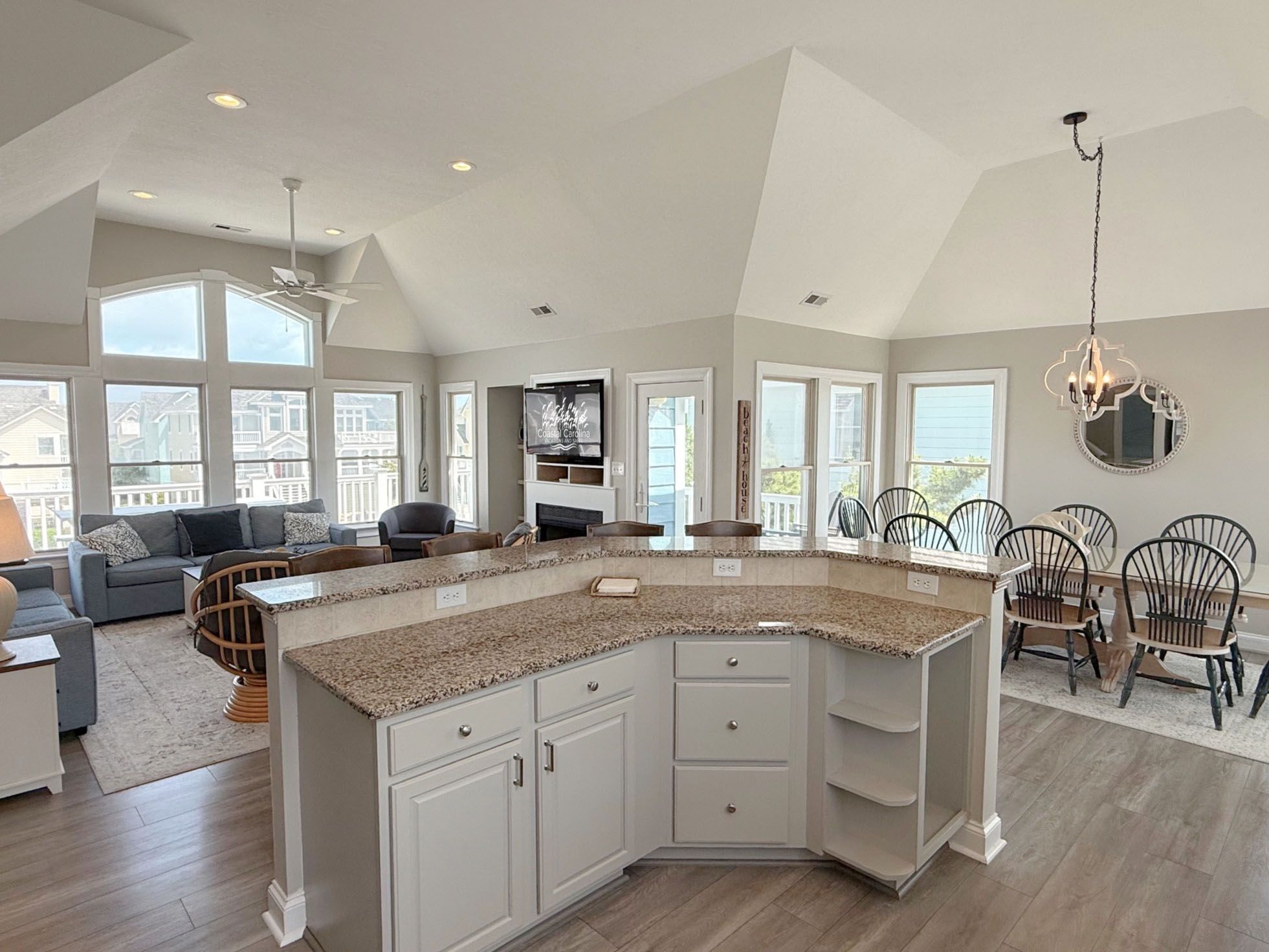 A spacious kitchen with a large island, white cabinetry, and a dining area with chairs.