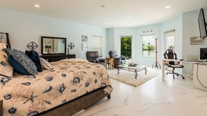 A spacious bedroom with a large bed, a desk, and a view of the outdoors. - Lovely water direct home with long water views. (Marco Island)